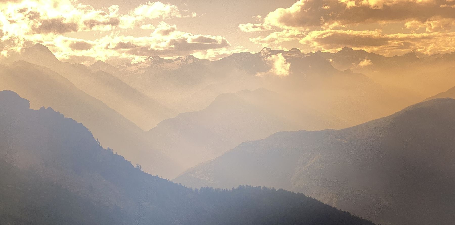 Sonnenlicht &uuml;ber gestaffelten Bergketten im Dunst